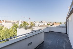 Amplia terraza en un edificio moderno con vistas urbanas, ideal para disfrutar del exterior y el buen clima de la ciudad. Espacio perfecto para relajarse y organizar eventos al aire libre.